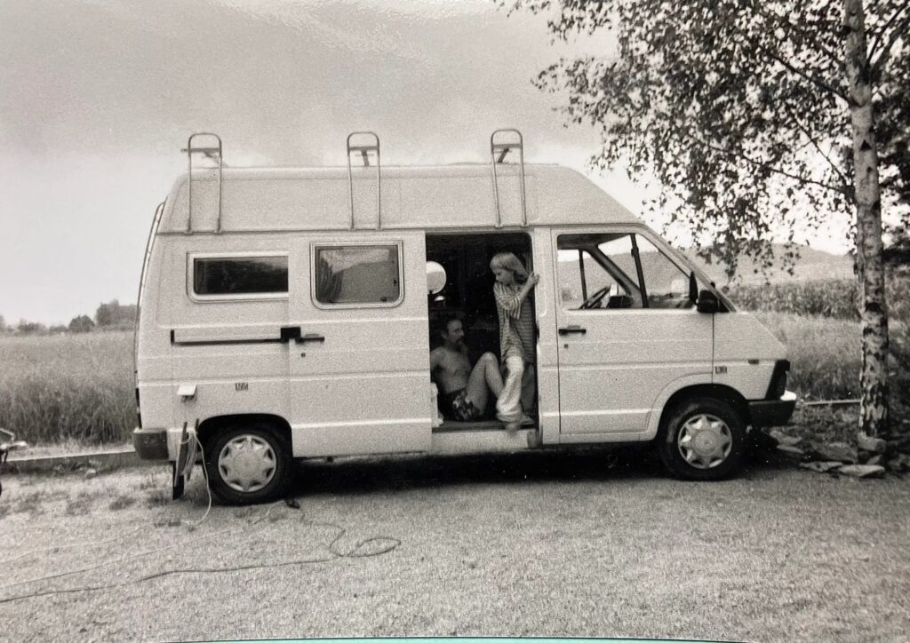 A black-and-white photo of Chris as a child with his dad in a white van.